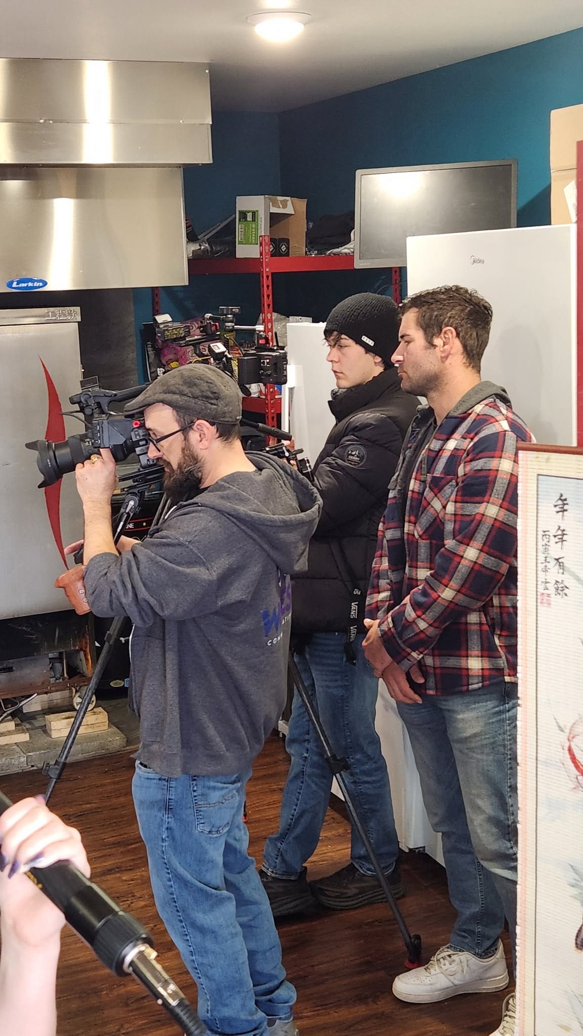 Jeremiah Rounds operating camera while directing The Columbia Coast in a kitchen